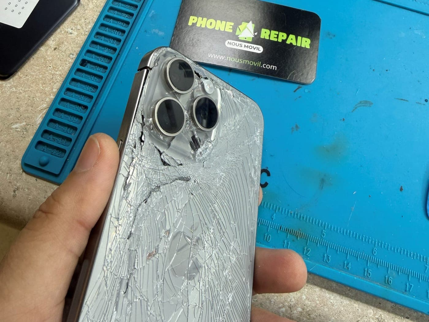 Vidrio trasero astillado de un iPhone Pro con el módulo de la cámara afectado